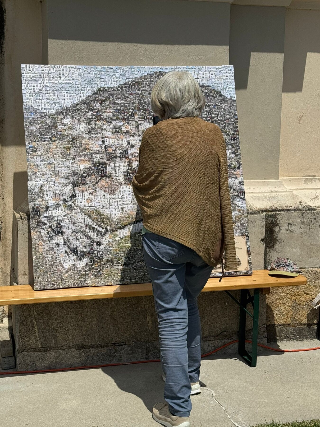 Una visitatrice osserva da vicino i frammenti fotografici dell’opera Aranno